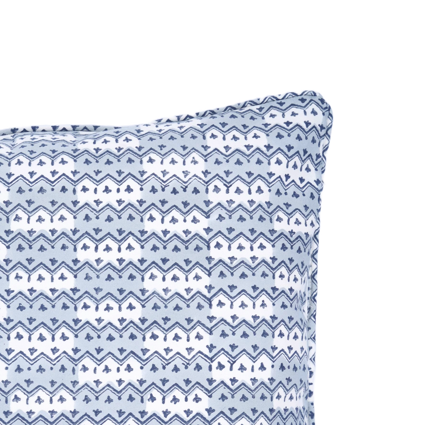 A close-up corner view of the hand-block printed Munnar Frost cushion on a white background. This detailed shot highlights the tailored piped edges and light blue and white geometric zig-zag pattern. This handcrafted textile adds a cozy modern rustic Canadian farmhouse aesthetic to your home decor.