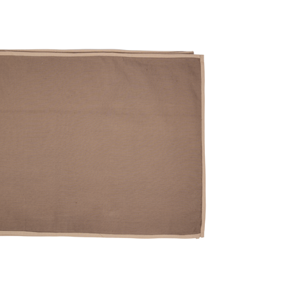 A rectangular brown fabric placemat with a beige border, shown folded on a plain white background.