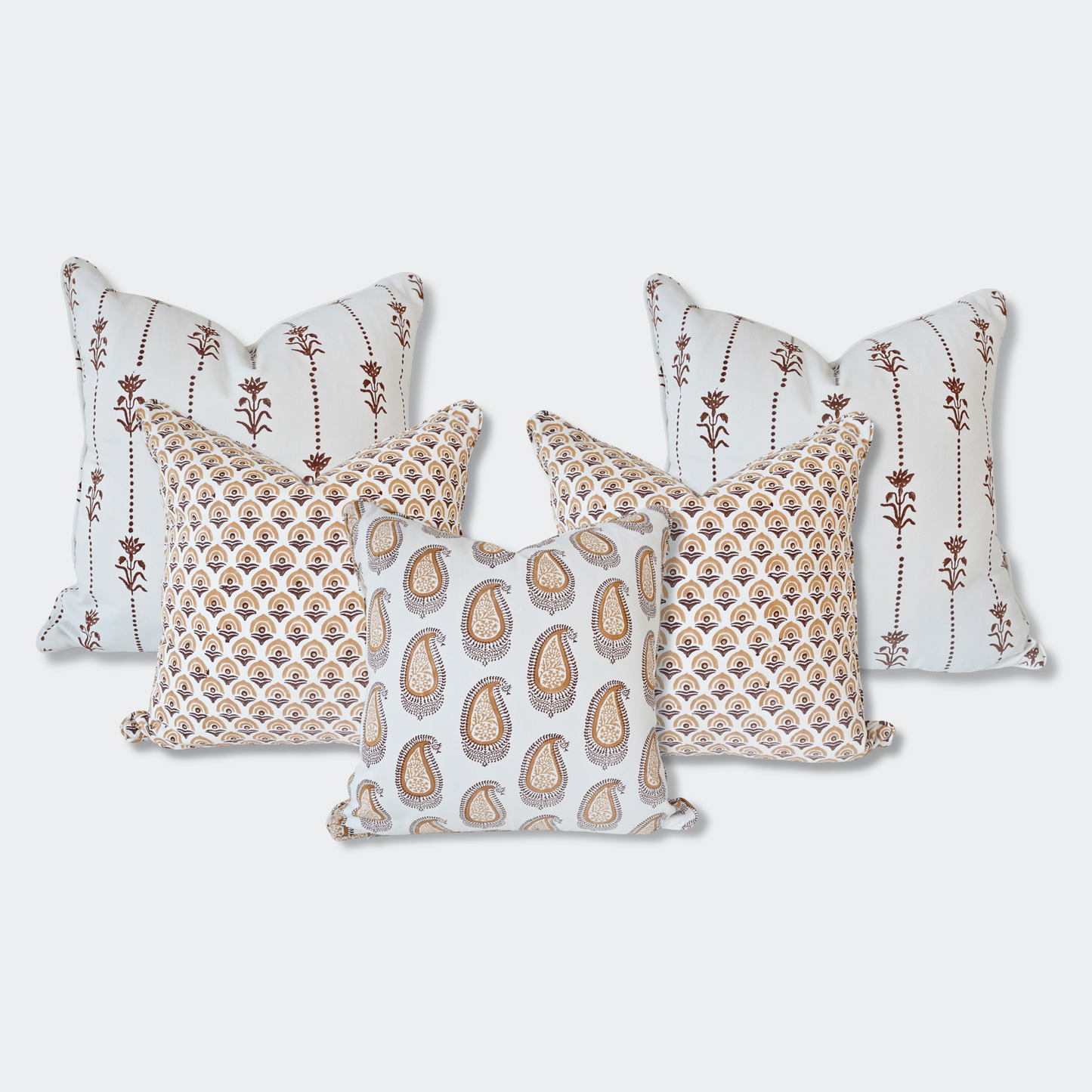 A curated set of five Homeway Living 100% cotton block-printed cushion covers on a light background. Features two back pillows with vertical brown floral motifs, two mid-layer pillows with an amber fan-arch pattern, and a front pillow with an amber paisley print. Finished with tailored piped edges, this artisan set offers a warm, high-end look ideal for modern rustic or Scandinavian home decor across Canada and the US.