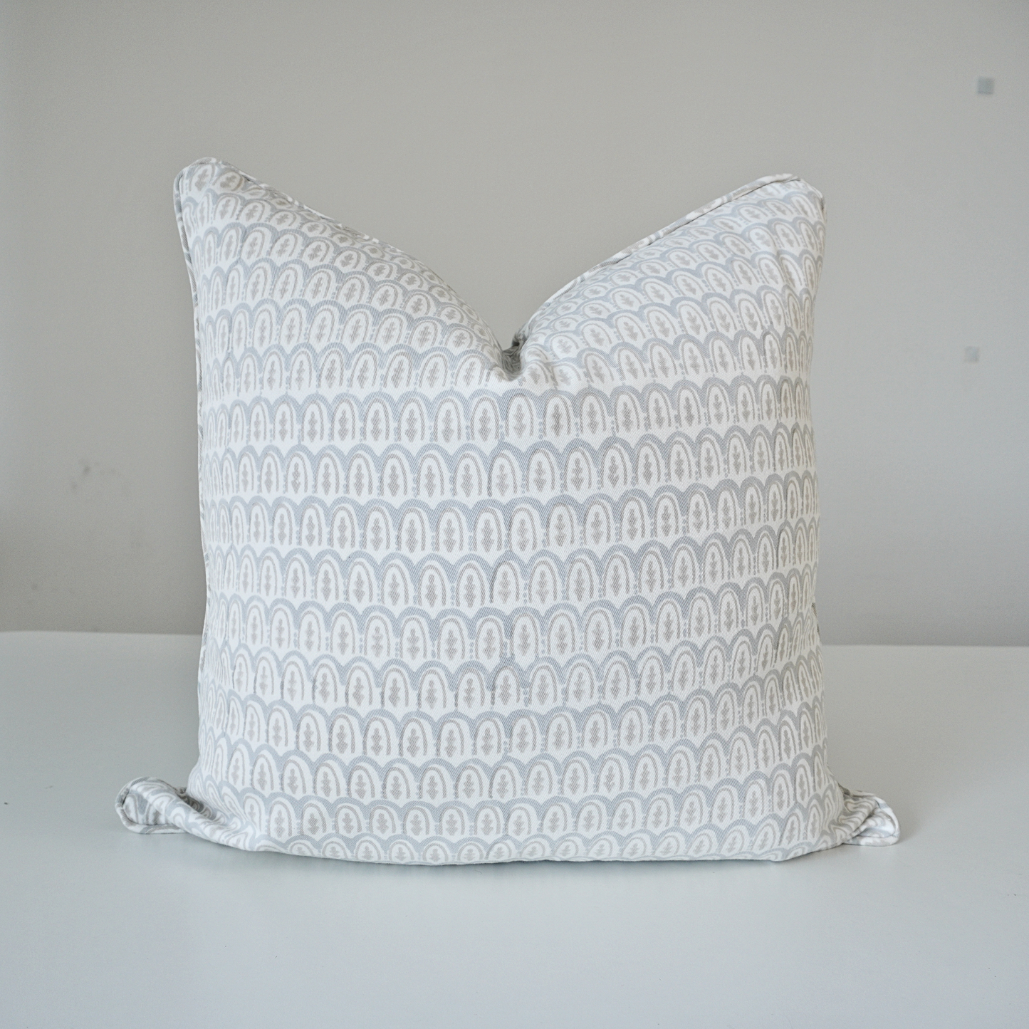 Square Bikaneri Muse grey and white 100% cotton block printed pillow cover. This artisan throw cushion features a repeating soft grey arched, scallop-inspired geometric pattern on a crisp white background with tailored piped edges. Fine handmade textile home decor.