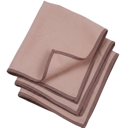 Folded brown and pink table napkins set of linen material  on a white background