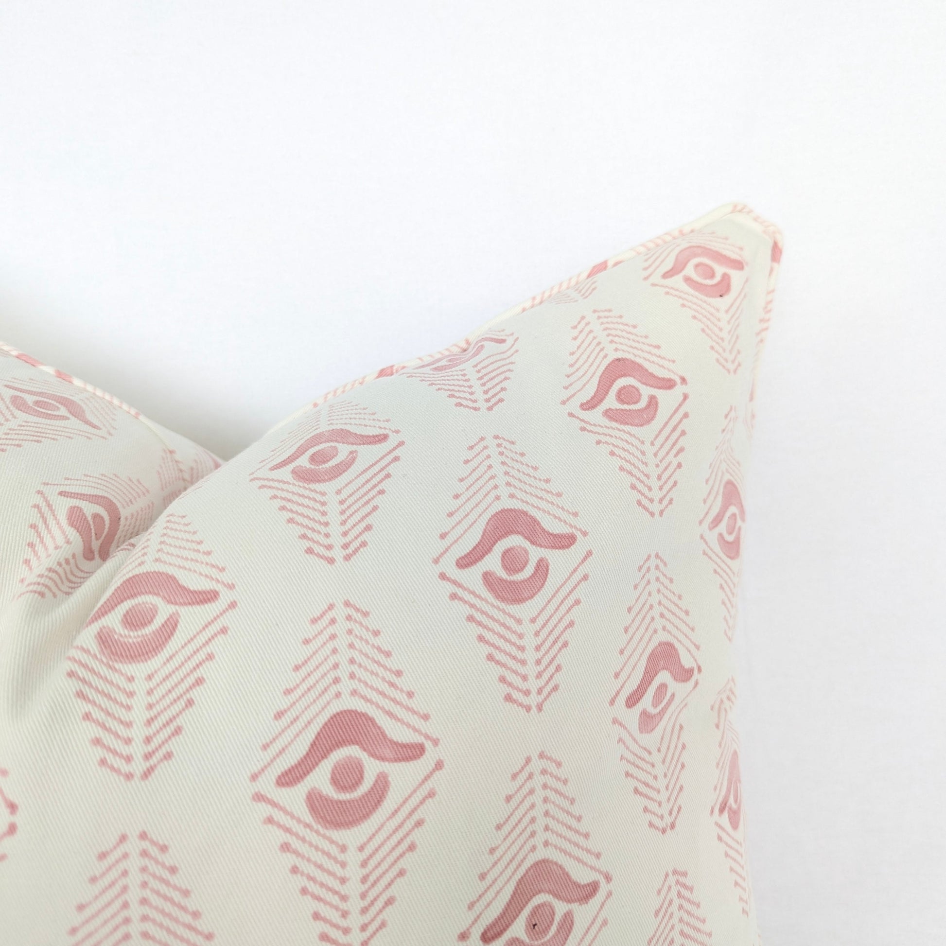 Decorative pillow with pink geometric pattern on a white background
