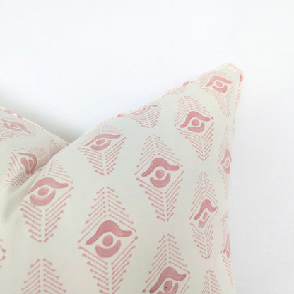 Decorative pillow with pink geometric pattern on a white background