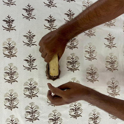 Artisan hands stamp an earthy brown floral pattern onto natural fabric with a carved wood block. This traditional hand-block printing process crafts our textiles, perfect for modern rustic farmhouse Canadian and USA home decor.