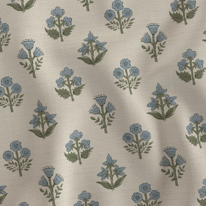 A close-up fabric swatch featuring a delicate light blue and green floral sprig block print pattern. Showcasing a natural textile texture, this artisanal print perfectly adds a cozy modern rustic farmhouse aesthetic to Canadian and USA home decor.