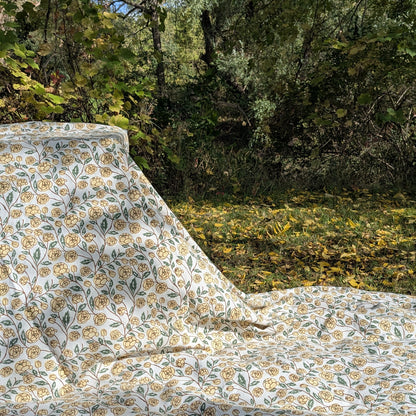 Block printed Floral patterned fabric with yellow flowers and green leaves on a white background