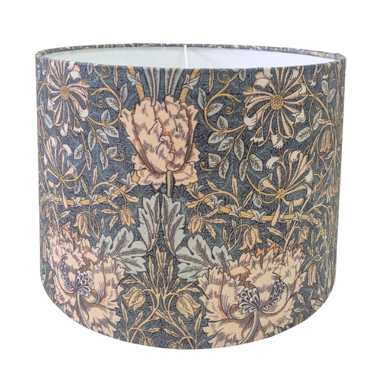 A drum lampshade featuring the classic William Morris Honeysuckle botanical pattern with peach flowers and green foliage on a dark background. This elegant vintage-style piece adds classic charm to a cozy modern rustic farmhouse aesthetic for both Canadian and USA home decor.