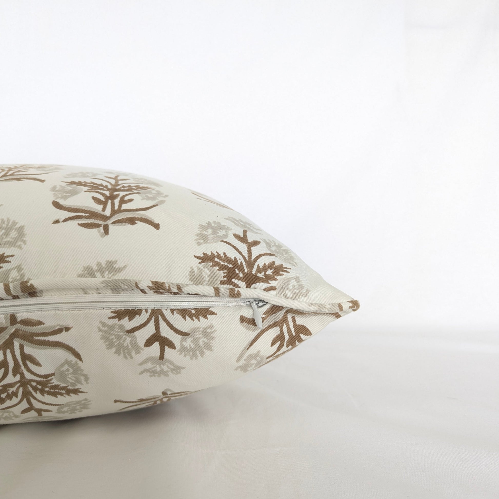 Close-up of an earthy brown and beige floral sprig hand-block printed cushion cover showing the neat concealed zipper. This artisanal throw pillow brings a warm, cozy modern rustic farmhouse aesthetic to Canadian and USA homes, blending seamlessly with natural living room and bedroom decor.