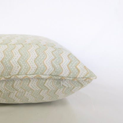 A close-up side view of the hand-block printed Myra Meadow mist cushion on a crisp white background. This detailed shot highlights the neatly sewn discreet hidden zipper closure and piped edges. The wavy sage green and tan chevron pattern showcases the quality of this handcrafted textile, perfectly adding a light, cozy modern rustic Canadian farmhouse aesthetic to your home decor.