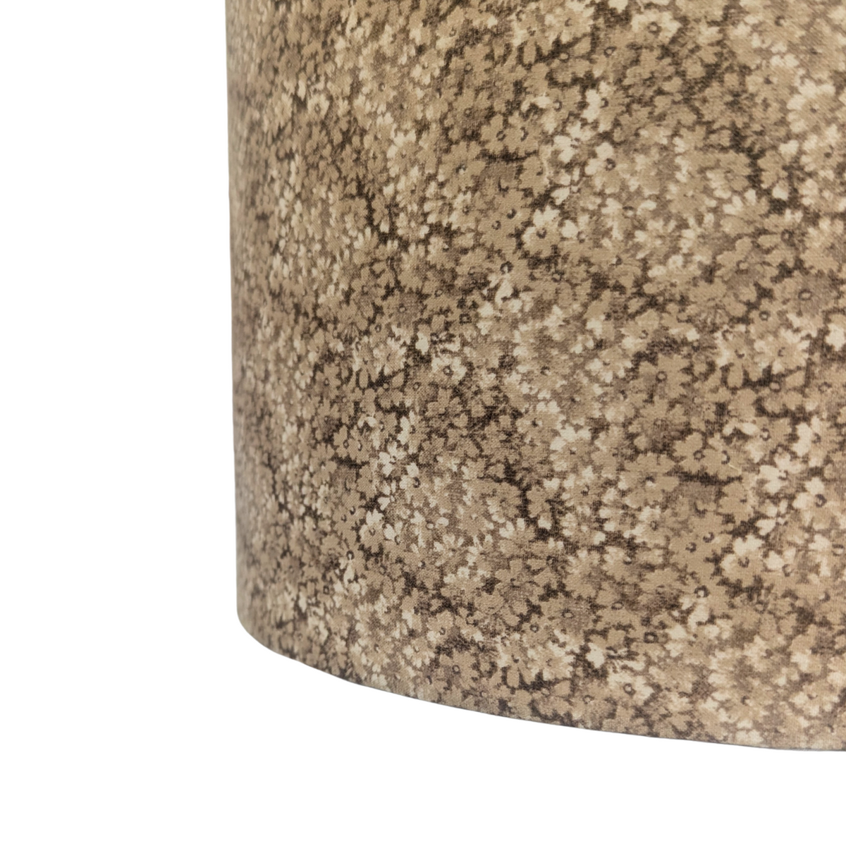 A close-up detail of a drum lampshade featuring the Penny Ditsy pattern, showcasing a delicate and dense earthy brown micro-floral print. This warm textile perfectly adds a cozy modern Canadian farmhouse aesthetic to any home decor.