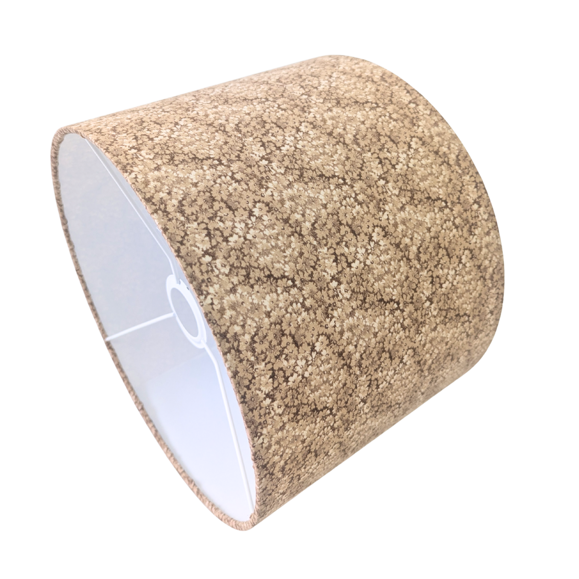 An angled interior view of a drum lampshade showing the white lining and metal spider fitting. The exterior features the Penny Ditsy pattern, a delicate earthy brown micro-floral print. This warm piece perfectly adds a cozy modern Canadian farmhouse aesthetic to home decor.