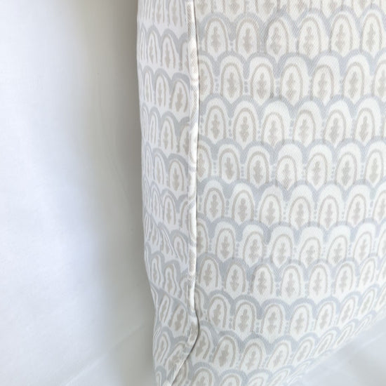 A close-up video showcasing a light blue and beige scalloped arch hand-block printed cushion cover. The textured natural fabric highlights traditional artisanal craftsmanship, perfect for bringing a cozy, modern Canadian rustic farmhouse aesthetic to your living room or bedroom decor.