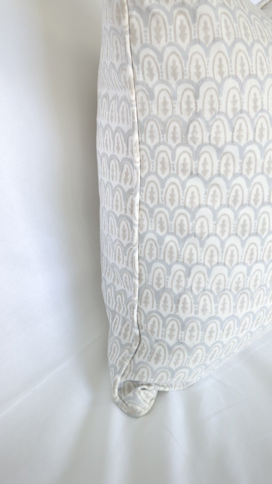 A close-up video showcasing a light blue and beige scalloped arch hand-block printed cushion cover. The textured natural fabric highlights traditional artisanal craftsmanship, perfect for bringing a cozy, modern Canadian rustic farmhouse aesthetic to your living room or bedroom decor.