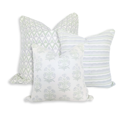 A studio shot of a curated trio of hand-block printed cushion covers in refreshing, airy tones of sage green and soft blue on crisp white fabric. The collection features an artful mix of a geometric triangle pattern, a horizontal striped and wavy design, and a delicate floral motif, perfectly adding a cozy modern rustic Canadian farmhouse aesthetic to any home decor.