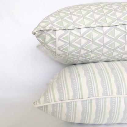 A studio shot of a curated trio of hand-block printed cushion covers in refreshing, airy tones of sage green and soft blue on crisp white fabric. The collection features an artful mix of a geometric triangle pattern, a horizontal striped and wavy design, and a delicate floral motif, perfectly adding a cozy modern rustic Canadian farmhouse aesthetic to any home decor.