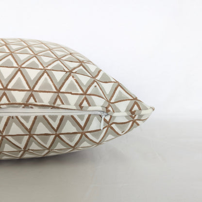 A close-up side view of a hand-block printed cushion featuring an earthy tan and soft grey geometric triangle pattern on a cream background. This detail shot highlights the neatly sewn discreet hidden zipper closure, showcasing the quality of this handcrafted textile that perfectly adds a cozy modern rustic Canadian farmhouse aesthetic to any home decor.