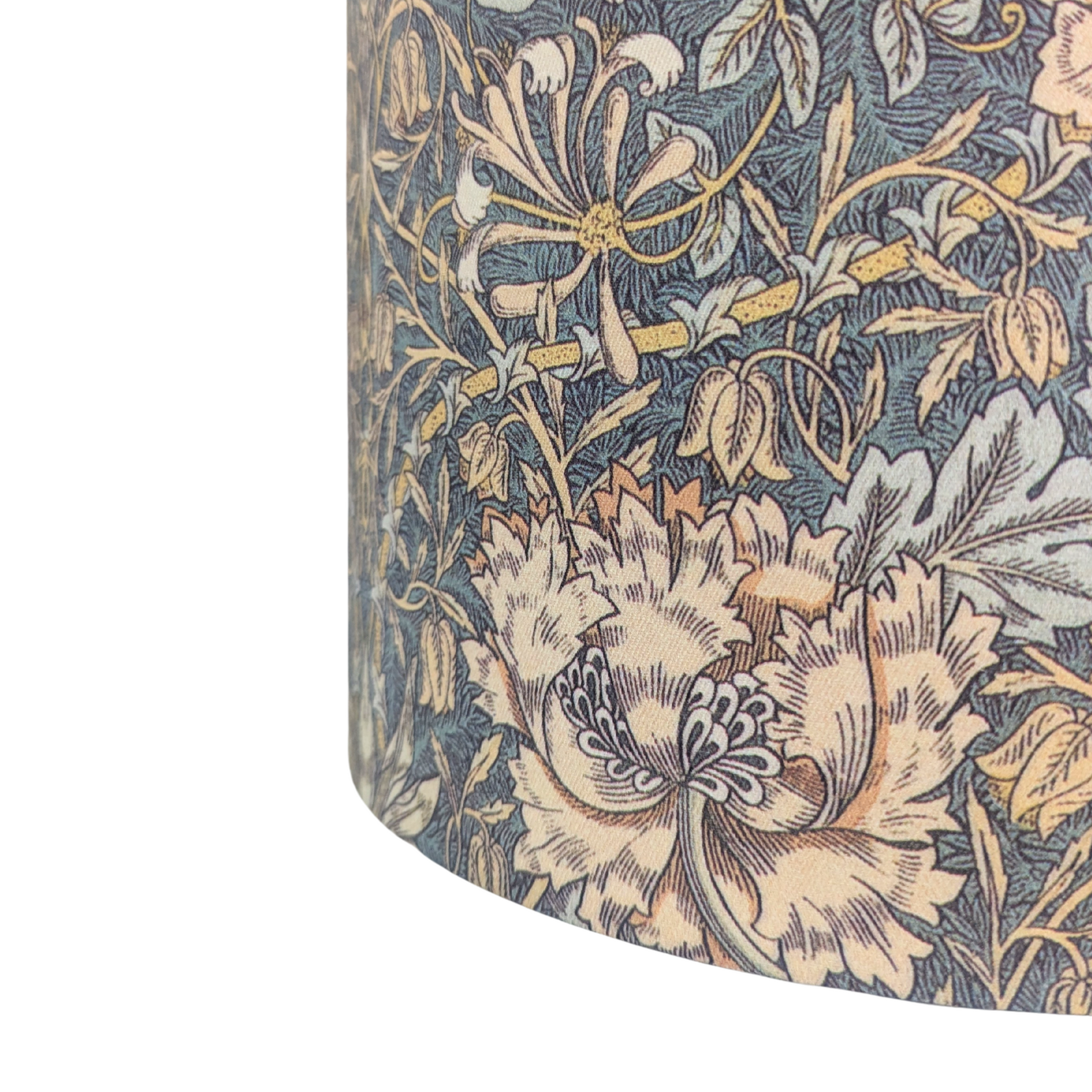 A close-up detail of a drum lampshade displaying the intricate William Morris Honeysuckle botanical pattern. Highlighting a beautifully detailed peach flower and intertwining green foliage on a dark background, this vintage-inspired piece adds classic modern rustic farmhouse charm to Canadian and USA home decor.